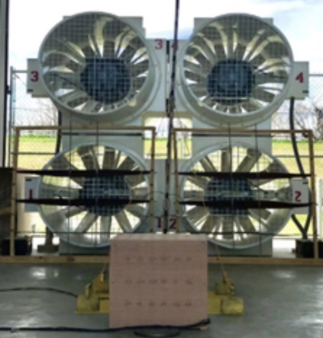 A cube building model with pressure taps in front of the four large fans