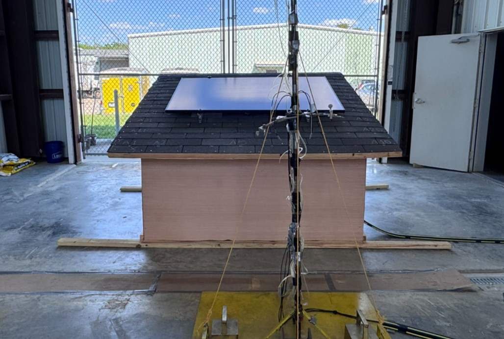 A mono-slope roof building with a rooftop solar panel, instrumented for pressure measurements